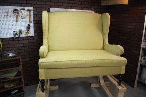 Wingback Settee on work horses ready for upholstery teardown.